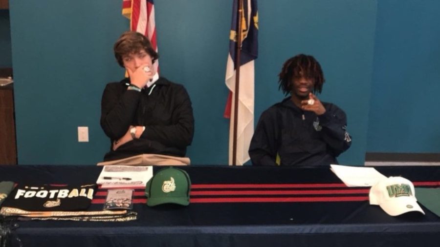 J is seen on the right, signing to play for the University of Mount Olive!