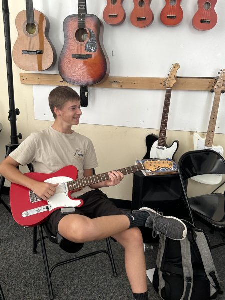 Caleb Heath playing guitar in Mr. Leonards music class