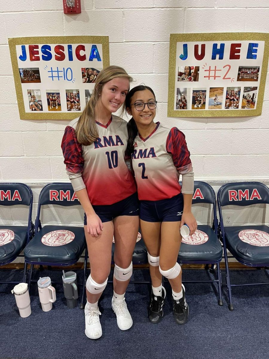 Juhee Desai and Jessica Proctor in front of their posters created by their teammates on Volleyball Senior Night!
